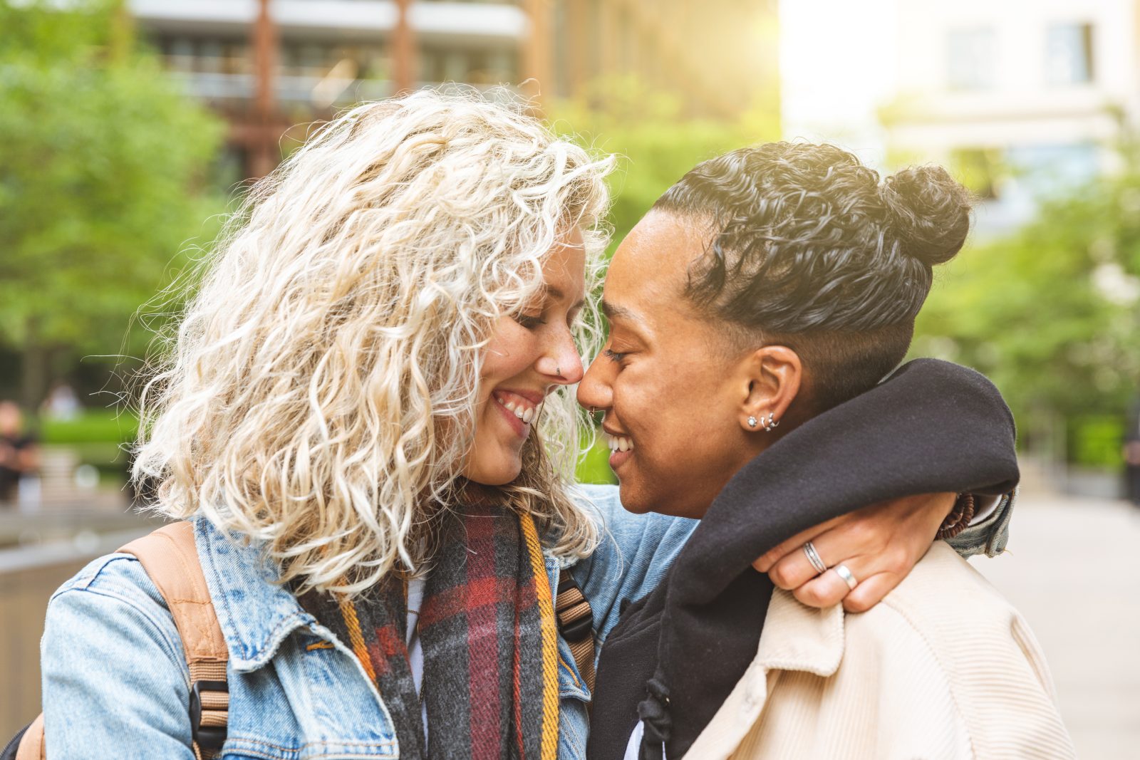 Two people in a tender embrace, foreheads touching and smiling