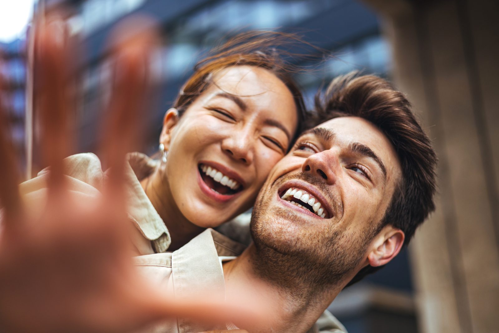 A joyful couple laughing together outdoors