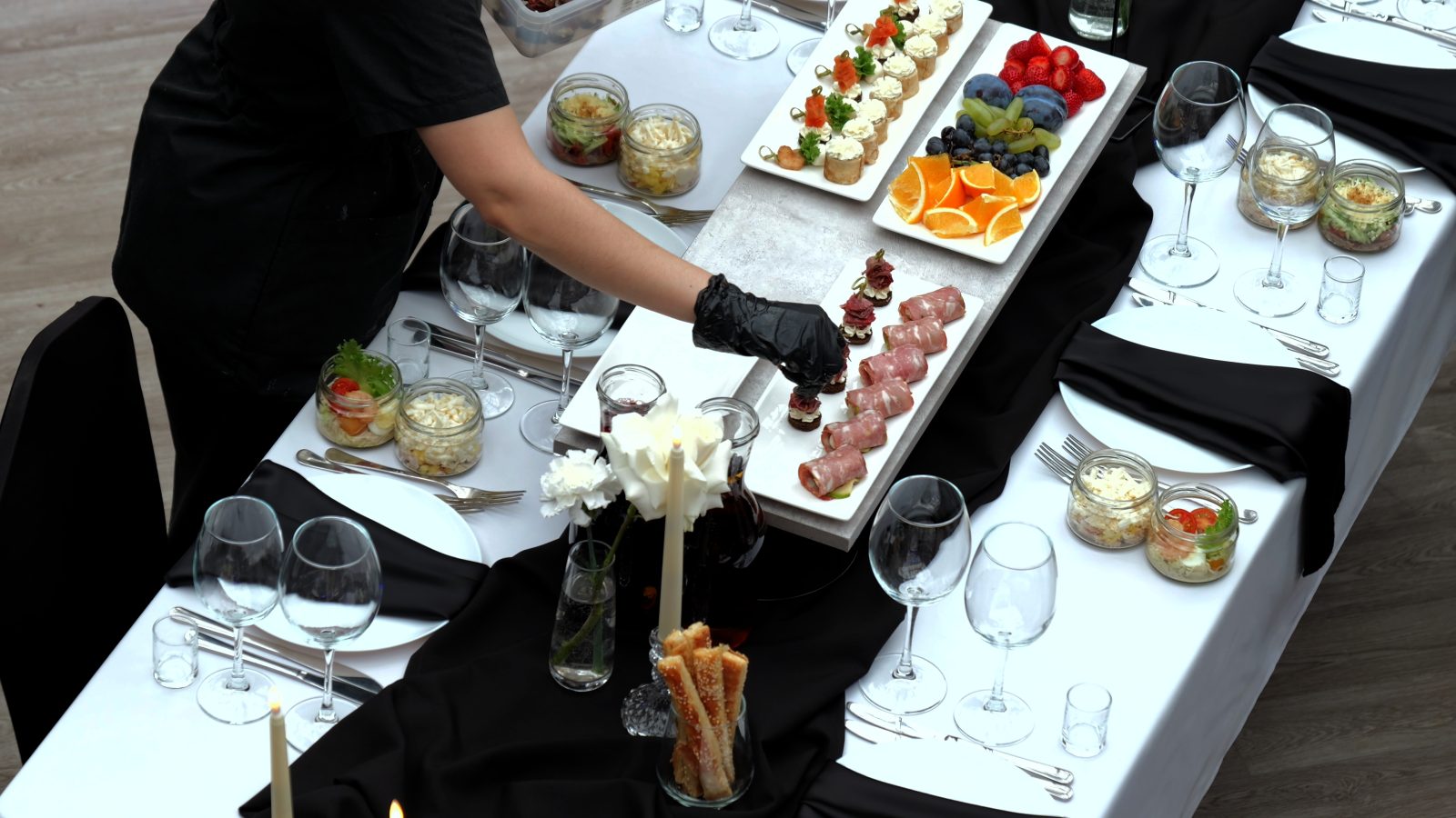 A caterer arranging an elegant table of appetizers
